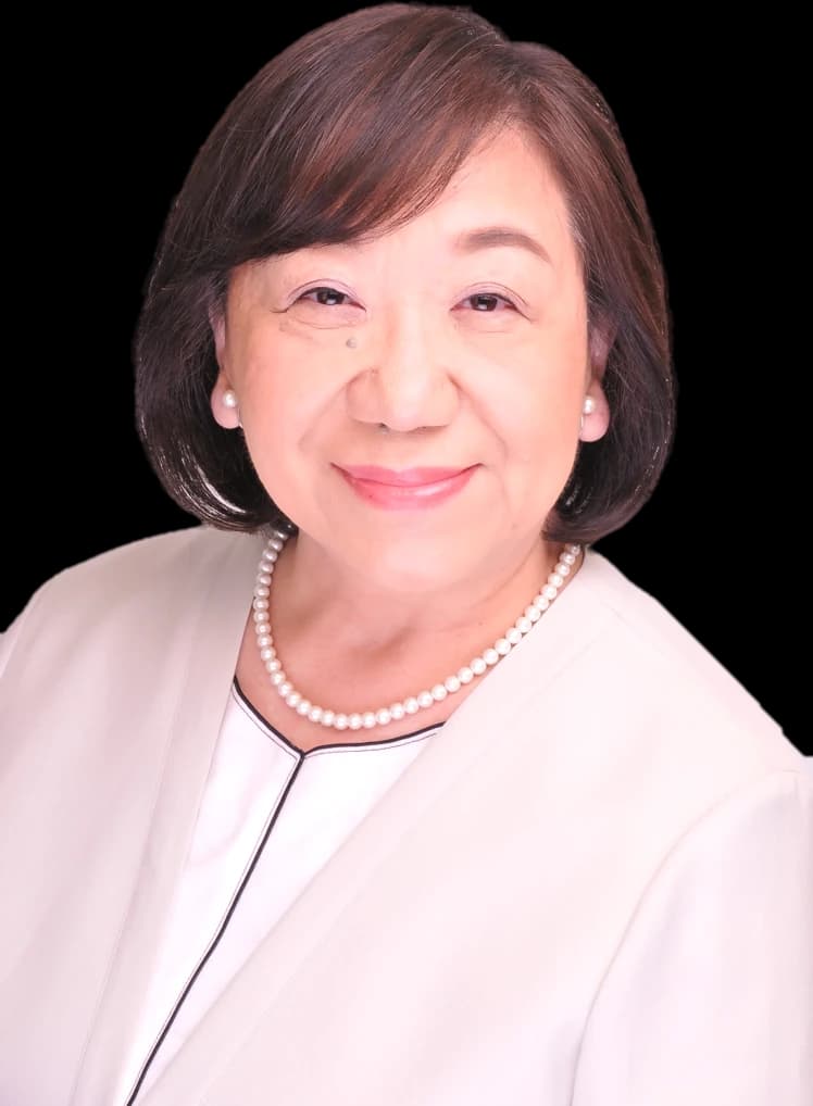 清田のり子の写真。白い上着に真珠のネックレスで、ほほえんでいる
